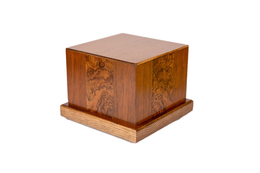 Angled view of handcrafted cremation urn made from 1920s Black Walnut with inlaid English Walnut Burl from an 1885 piano and Sitka Spruce top reclaimed from antique soundboard, 54 cubic inch capacity, satin finish, early American brown tone