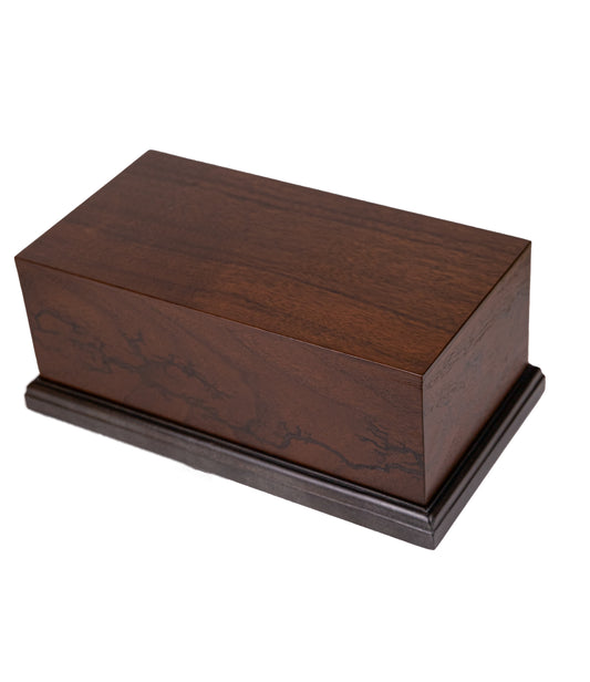 Handcrafted cremation urn with Black Walnut body featuring Lichtenberg figure wood burn detailing, Honduran Rosewood top, and blackened Figured Maple base, 260 cubic inch capacity, angled view