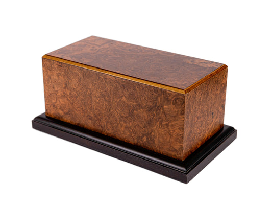 Angled view of 120 cubic inch cremation urn made from 1890 British piano wood with English Walnut Burl grain and black base in satin finish