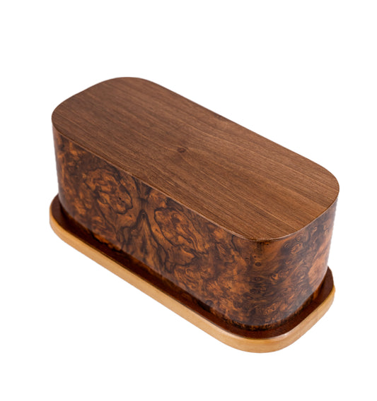 Angled view of 165 cubic inch urn crafted from English Walnut Burl book matched from an 1890 British piano key cover, preserving vintage elegance