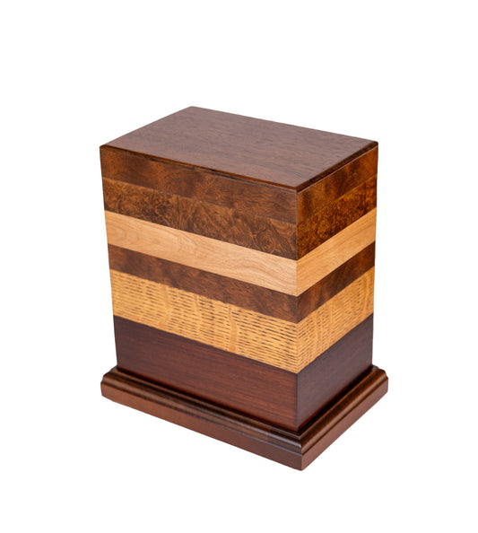 Handcrafted cremation urn featuring a blend of English Walnut Burl, Black Walnut, American Ash, Quarter Sawn Oak, Brazilian Rosewood, Honduran Rosewood top, and Cuban Mahogany base with Walnut accents, 200 cubic inch capacity, angled view