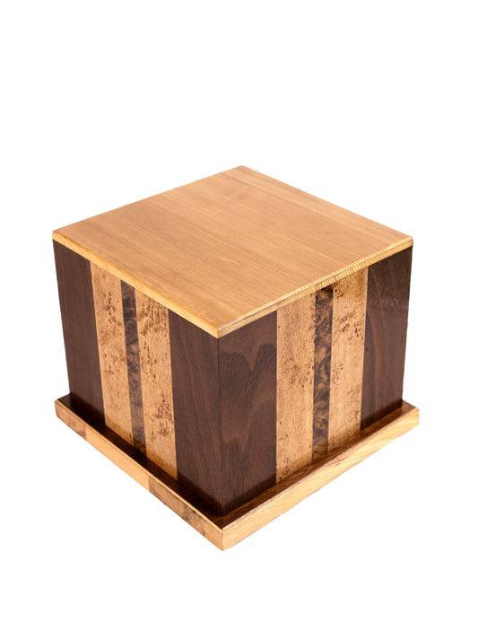 Angled view of 160 cubic inch urn of English Walnut Birdseye with Walnut border, Walnut Burl inlay, and Spruce top, made from piano wood